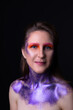 Fashion model woman girl with bright purple sequins on the skin of the face and body, concept of the season spring
