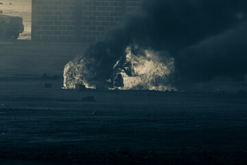 Wall Mural - Military strike on a car sets it on fire after a riot in war. Smoke and flames fill the air. Military concept. War, strength, explosion.