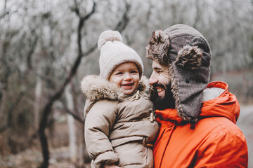 Canvas Print - Handsome young dad and his little sweet daughter have fun outdoors in winter. Happy family spending time together. Family concept.