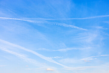 Canvas Print - several old contrails and cirrus clouds in blue sky on autumn day