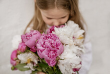 Portrait Of A Little Girl Smelling The Peonies