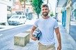 © Krakenimages.com - Young hispanic man smiling happy holding motorcycle helmet walking at the city