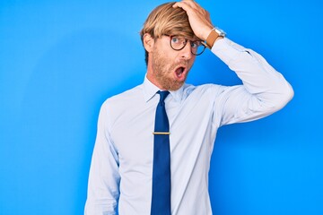 Sticker - Young blond man wearing business clothes and glasses surprised with hand on head for mistake, remember error. forgot, bad memory concept.