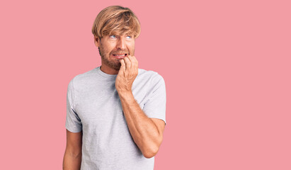 Poster - Handsome caucasian man with beard wearing casual tshirt looking stressed and nervous with hands on mouth biting nails. anxiety problem.