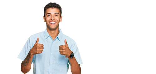 Young handsome african american man wearing casual clothes success sign doing positive gesture with hand, thumbs up smiling and happy. cheerful expression and winner gesture.