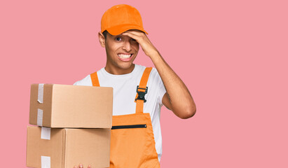 Sticker - Young handsome african american man holding delivery package stressed and frustrated with hand on head, surprised and angry face