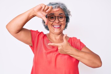 Sticker - Senior hispanic grey- haired woman wearing casual clothes and glasses smiling making frame with hands and fingers with happy face. creativity and photography concept.