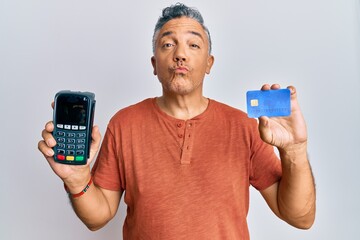 Poster - Handsome middle age mature man holding dataphone and credit card looking at the camera blowing a kiss being lovely and sexy. love expression.