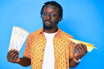 Poster - Young african american man with braids holding paper airplane and boarding pass skeptic and nervous, frowning upset because of problem. negative person.