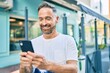 © Krakenimages.com - Middle age handsome man smiling happy using smartphone at the city.