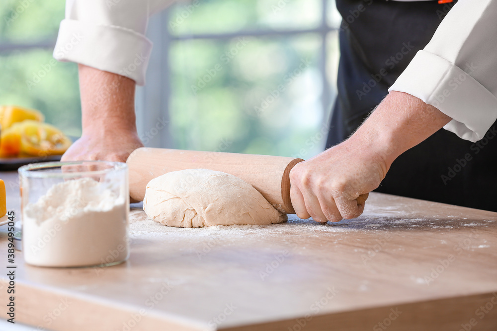 Female chef making dough in kitchen, closeup