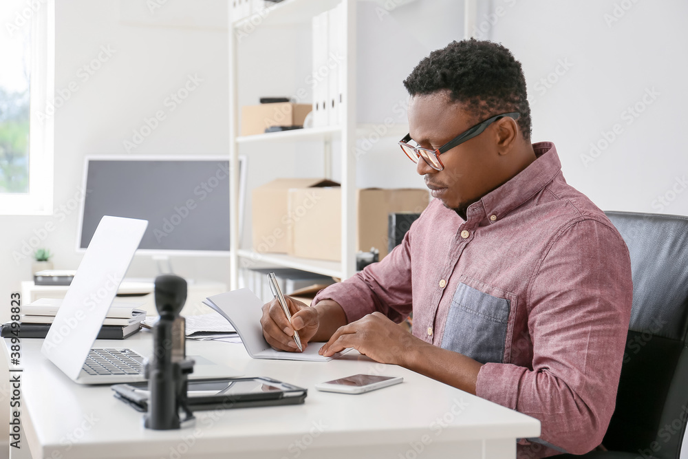 African-American technician repairing computer in service center