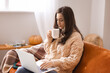 © Pixel-Shot - Beautiful young woman with laptop and cup of tea at home