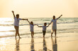© CandyRetriever  - Happy Asian Family parents with two child boy and girl holding hands and walking together on the beach at summer sunset. Father, mother and kids enjoy and having fun in outdoor holiday vacation.