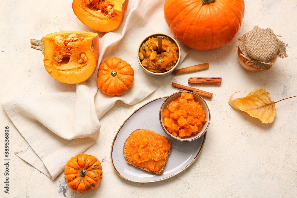 Autumn composition with tasty pumpkin jam on white background