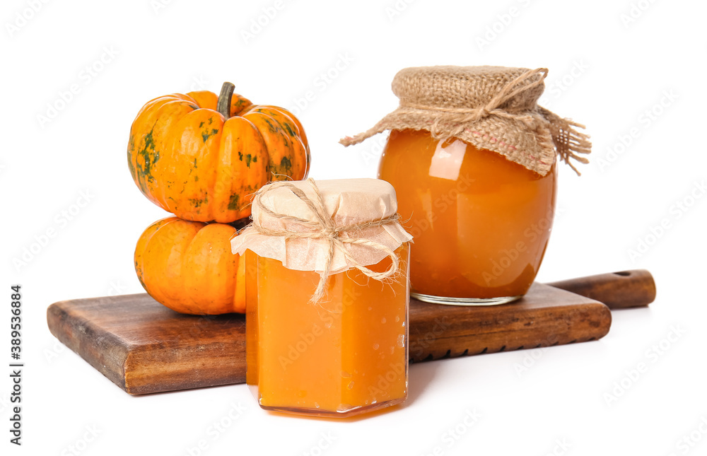 Jars of tasty pumpkin jam on white background