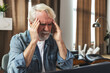 © kucherav - Elderly man holding his head experiencing headache and stress due to pressure