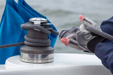 Woman Hands In Gloves Holding The Rope On Sailing Boat Yacht Sheet Winch Closeup On Water Sea Background