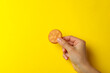 Female hand hold cracker biscuit on yellow background