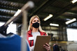 © Halfpoint - Volunteer working with food and clothes in community charity donations center, coronavirus concept.