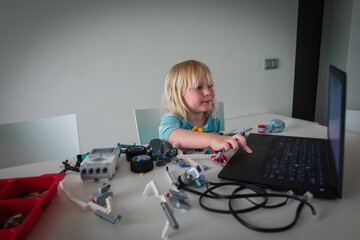 Poster - little girl building robots from colorful plastic blocks