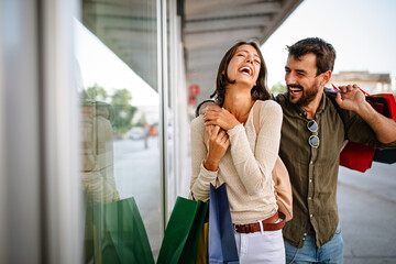 Beautiful young loving couple walking by the street while shopping and traveling