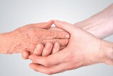 Man holds hands of eldery woman. Senior help and assistance concept.