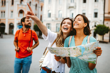 happy traveling tourists sightseeing with map in hand