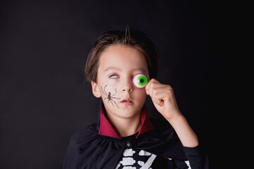 Wall Mural - Child, dressed for Halloween, playing at home, isolated image on black