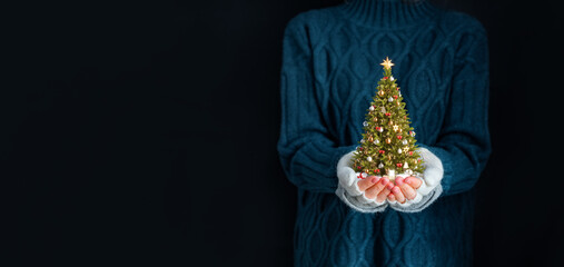 Wall Mural - Cute woman holds decorated christmas tree in her hands. Merry Christmas and a Happy new year concept