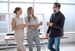 © ASDF - business team discussing something standing in the office