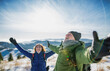 © Halfpoint - Senior couple hikers in snow-covered winter nature, stretching arms.