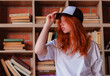 © oleg_ermak - Portrait of a redhead woman in template blank t-shirt and cap with healthy freckled skin. Young caucasian model posing on bookshelf background. Copy space and mock up. Place for adverising