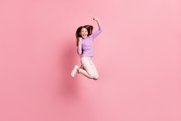 Sticker - Full size photo of ecstatic little girl jump raise fists wear purple sweater isolated over pastel color background