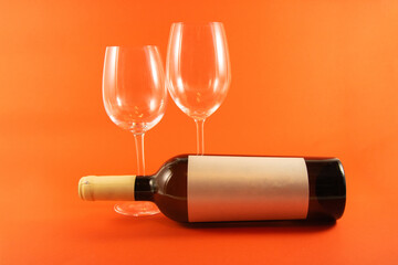 wine bottle with 2 glasses on a orange background