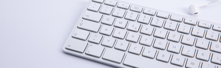 Wall Mural - new modern keyboard with snew modern keyboard with smartphone and earphones isolated on white background, close view martphone and earphones isolated on white background, close view . High quality