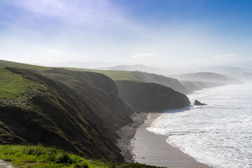 Canvas Print - green grassy cliffs drop down to the ocean coast in northern Spain