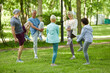 © Seventyfour - Group of modern senior people spending sunny morning in park doing stretching exercise