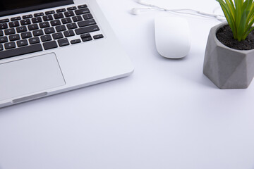 Wall Mural - new modern laptop keyboard with computer mouse and earphones with plant in pot isolated on white background, close view . High quality photo