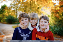 Portrait Of Three Siblings Children. Two Kids Brothers Boys And Little Cute Toddler Sister Girl Having Fun Together In Autumn Park. Happy Healthy Family Playing, Walking, Active Leisure On Nature