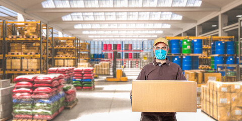 Wall Mural - man with mask and parcel, interior of an industrial warehouse