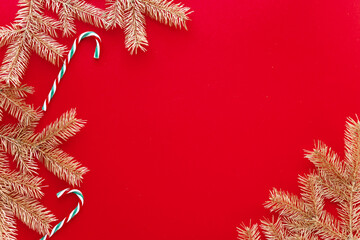 Red Christmas or new year background,simple composition of Golden fir branches and christmas toys,Flatlay,empty space for greeting text.