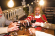 © DisobeyArt - Multiracial senior people celebrate new year's eve together doing dinner outdoor - Holidays concept - Soft focus on african woman face