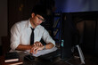 Asian businessman looking clock watch sitting at the desk working late, overtime night working or studying concept