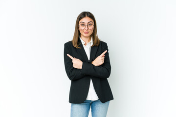 young caucasian business woman points sideways, is trying to choose between two options.