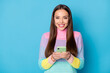 Close-up portrait of attractive cheerful girl using gadget browsing media wi-fi service isolated over bright blue color background
