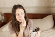 © iKagadiy - young woman removes cosmetics from her face with a cotton pad in the bedroom in front of the mirror. problem skin, rashes, imperfections