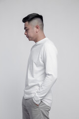 Wall Mural - Man posing with white long sleeve t shirt isolated on plain background.