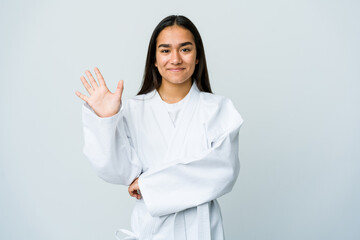 Wall Mural - Young asian woman doing karate isolated on white background smiling cheerful showing number five with fingers.