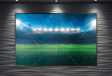 Watching A Soccer Event On A Large TV Wall Mounted And Illuminated By Spotlights